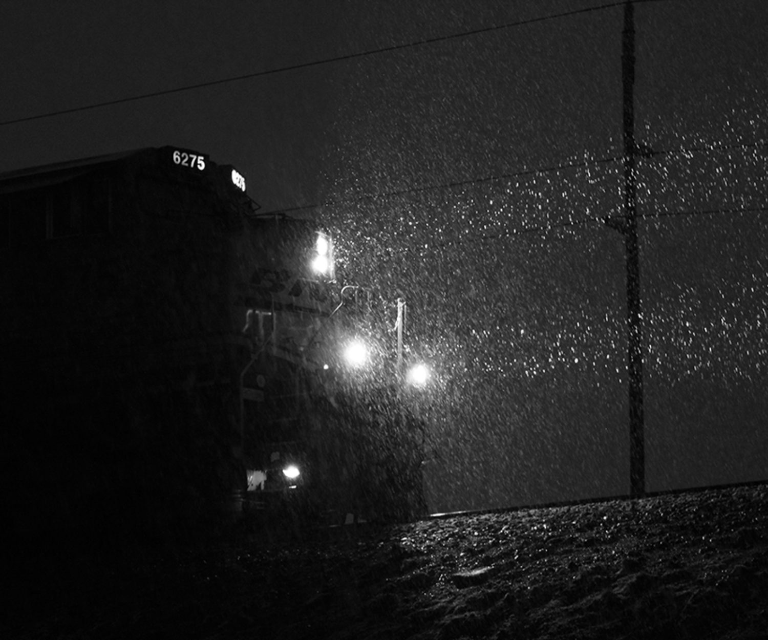 locomotive at night illuminating falling snow